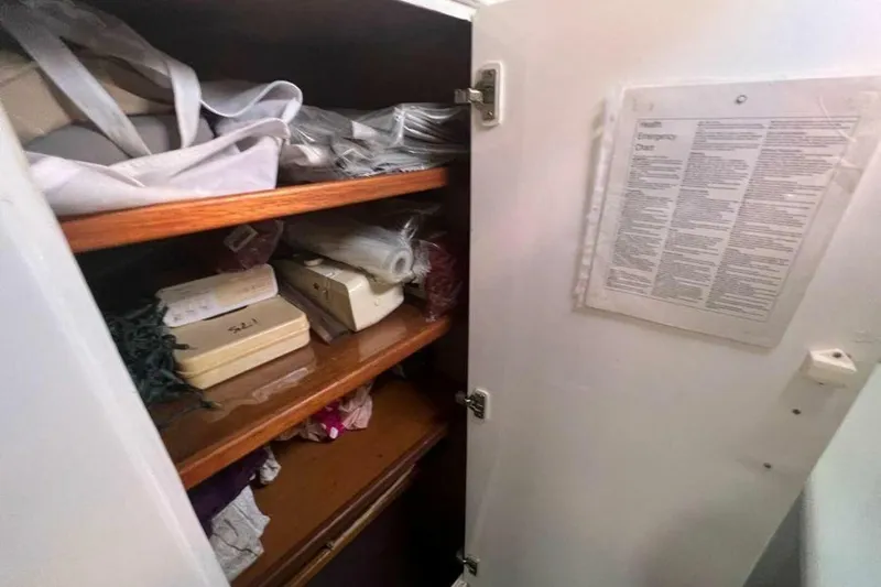 Slide: The Image of A cabinet with shelves full of sailing gear and an emergency chart on the door. - 15