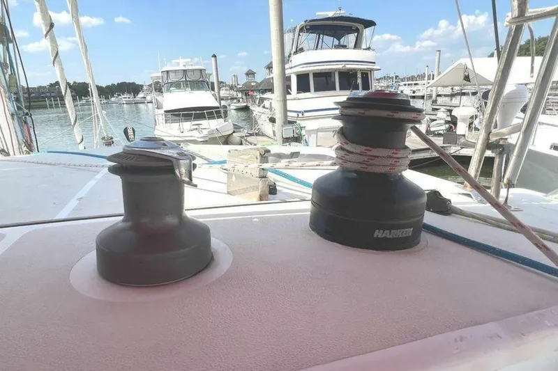 Slide: The Image of The image shows a sailboat deck with two winches in the foreground, surrounded by other boats in a marina. - 45