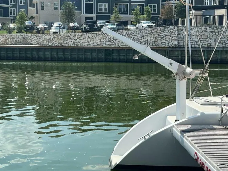 Slide: The Image of A 1995 Voyage Yachts Mayotte catamaran is docked by the water, with a stone wall and modern buildings. - 6