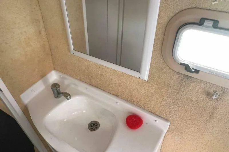 Slide: The Image of A simple sink with a mirror and porthole in a boat. - 20