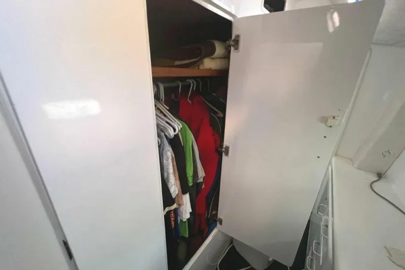 Slide: The Image of An open closet with clothes and blankets inside a boat. - 16