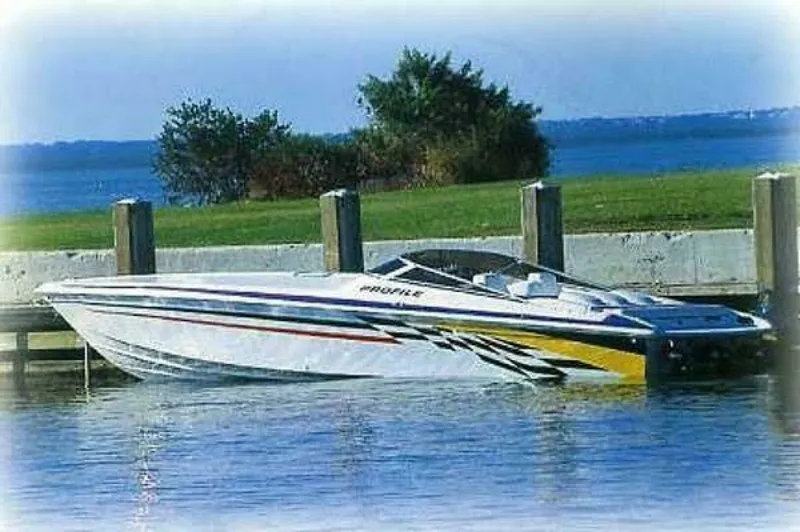 The Image of 2002 Profile 33 V: Sleek speedboat docked, featuring stylish design and colorful accents. - 0