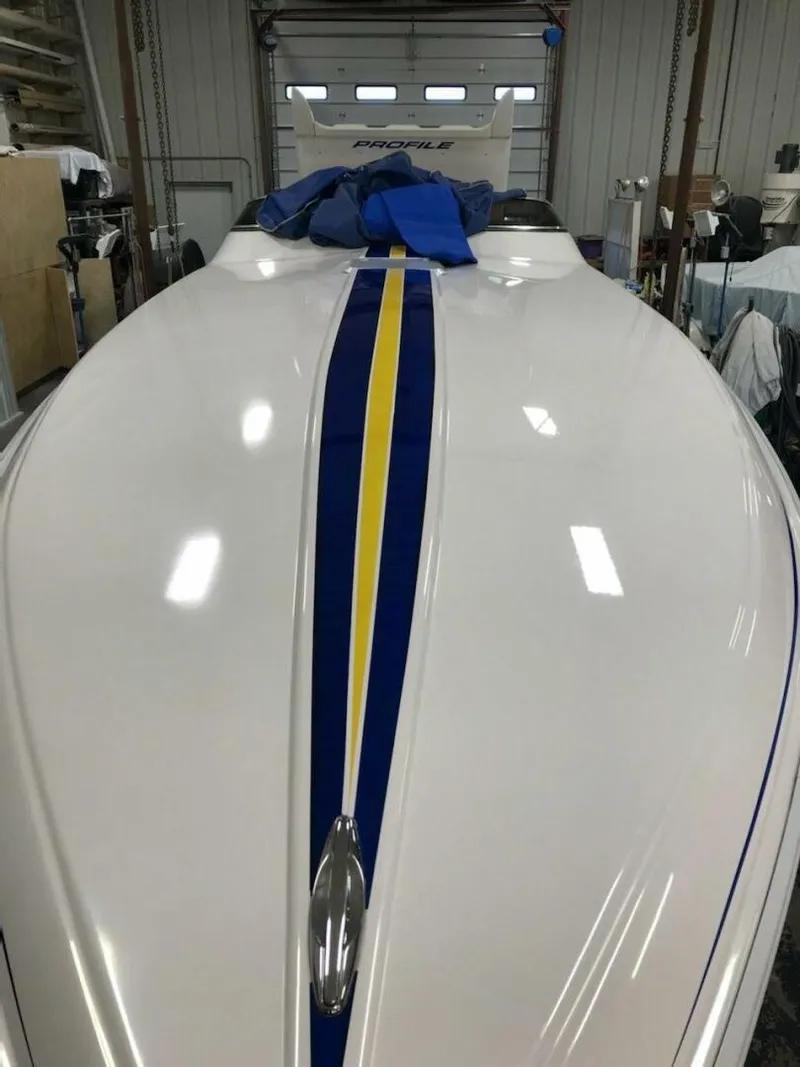 Slide: The Image of A 2002 Profile 33 V boat with a blue and yellow stripe in a garage. - 14