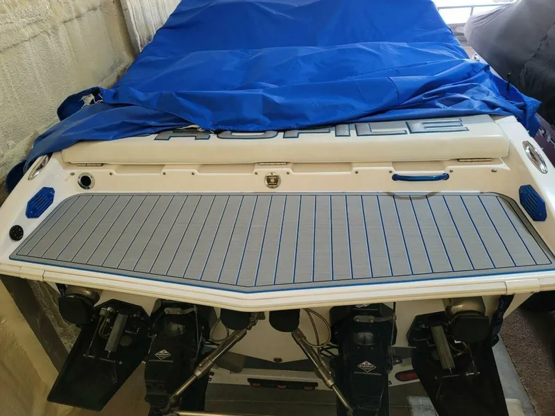 Slide: The Image of Rear view of a 2002 Profile 33 V boat with blue cover and dual engines. - 19
