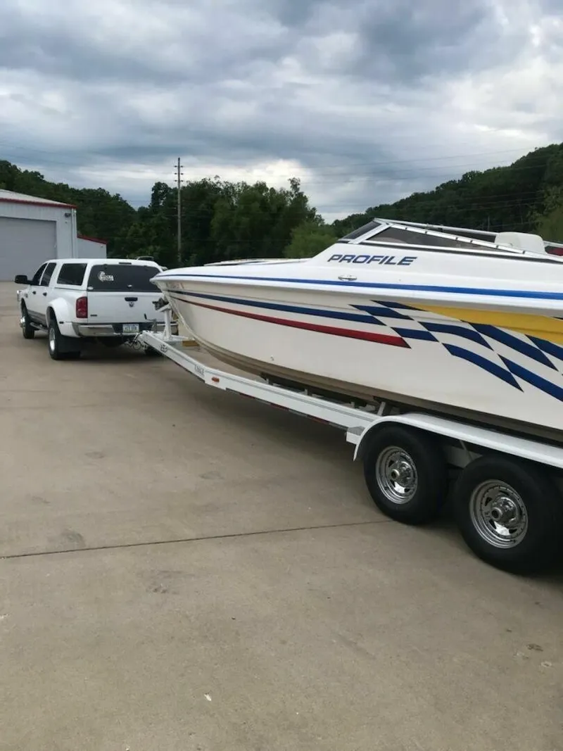 Slide: The Image of A white boat with colorful stripes on a trailer, towed by a white truck. - 15