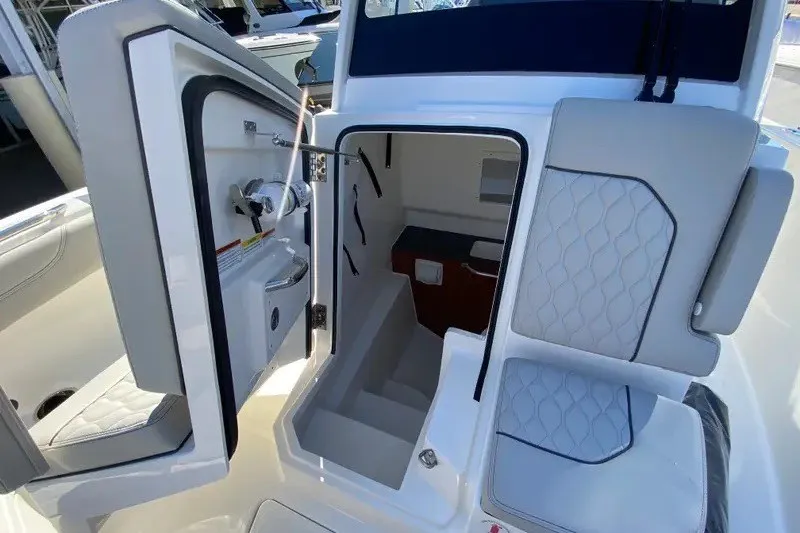 Slide: The Image of 2026 Pursuit S 288 Sport boat interior with open cabin door and seating. - 9