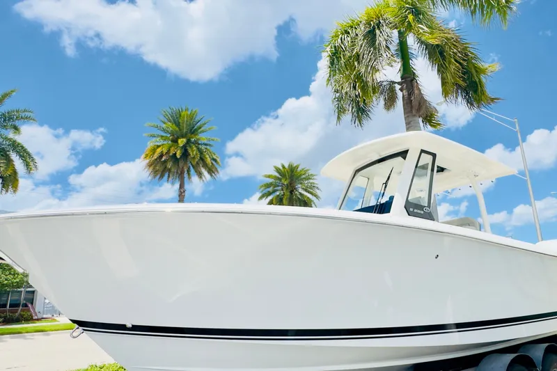 Slide: The Image of 2026 Pursuit S 288 Sport boat under palm trees and blue sky. - 15