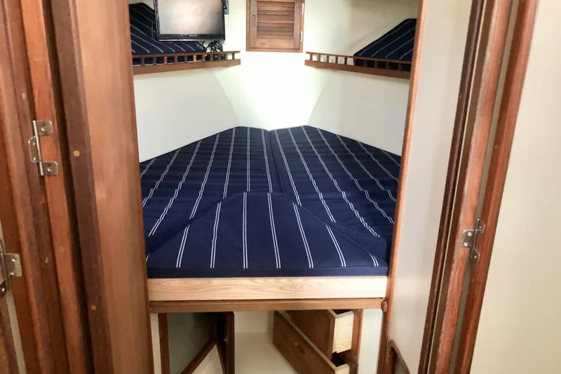 Slide: The Image of Cabin interior of 2018 Eastern 35 Casco Bay boat with striped bedding. - 19