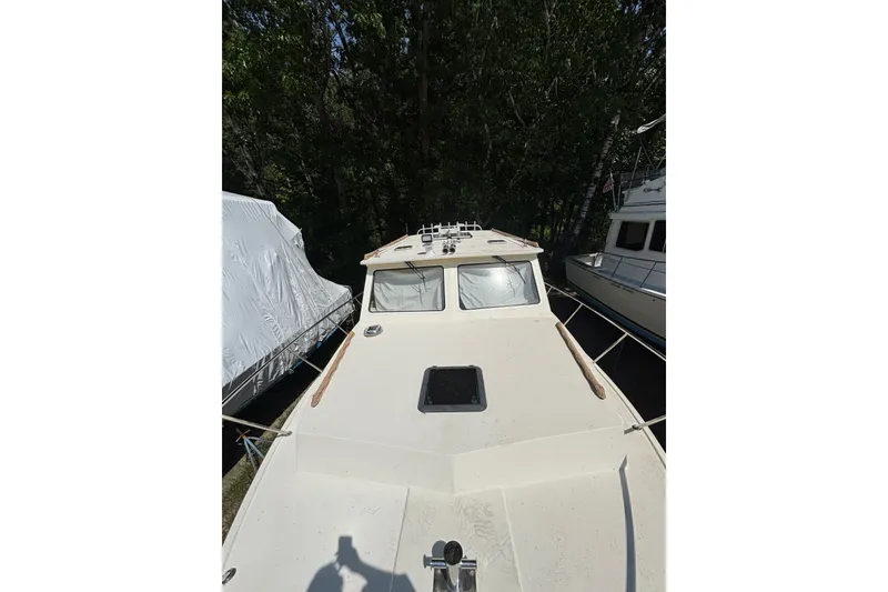 Slide: The Image of 2018 Eastern 35 Casco Bay boat docked, surrounded by trees and other vessels. - 34