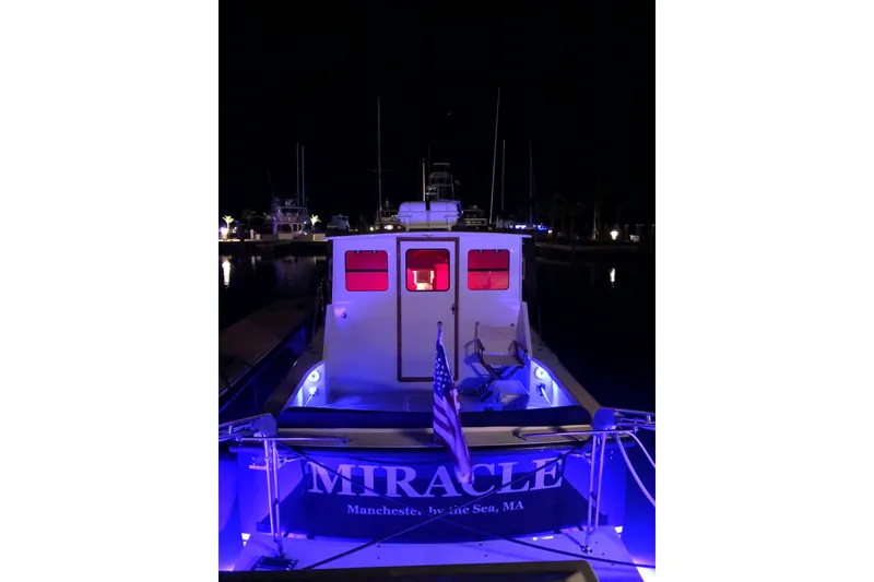 Slide: The Image of Eastern 35 Casco Bay boat, 2018 model, illuminated at night with blue lights in a marina. - 4