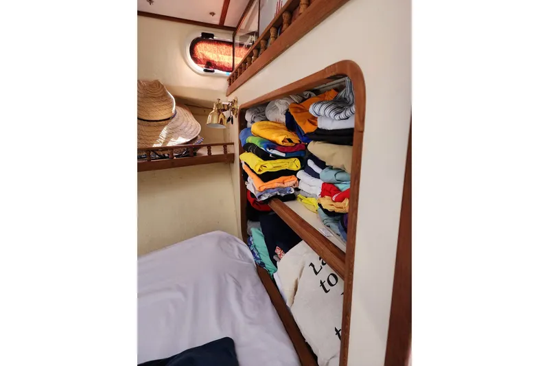 Slide: The Image of Cozy cabin interior of 2018 Eastern 35 Casco Bay with neatly stacked clothes and hats. - 25