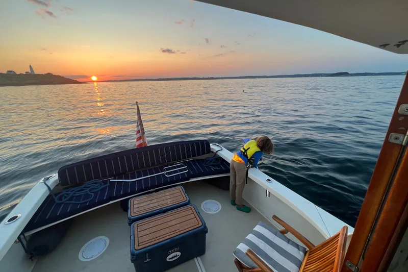 Slide: The Image of A child on a 2018 Eastern 35 Casco Bay boat at sunset, overlooking the ocean. - 7