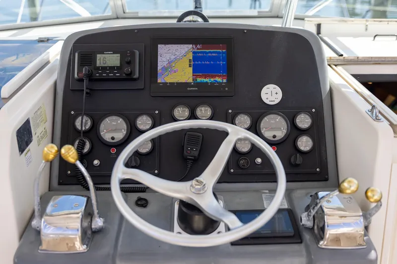 Slide: The Image of 1997 Tiara Yachts 3500 Express helm with navigation instruments and steering wheel. - 22