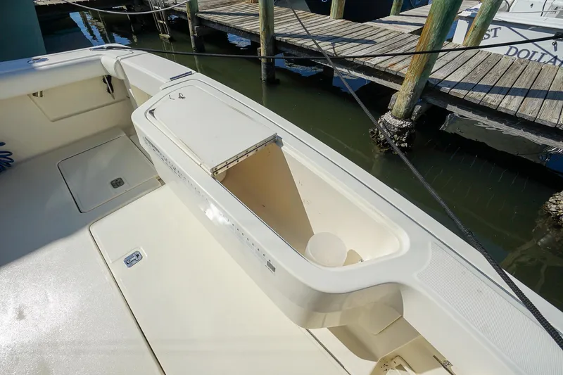 Slide: The Image of 1997 Tiara Yachts 3500 Express boat deck with storage compartment, docked at marina. - 41