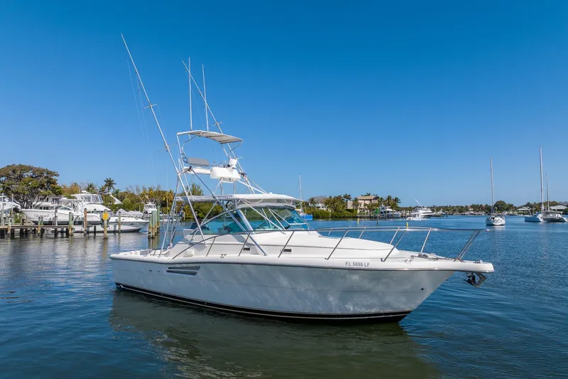 Slide: The Image of 1997 Tiara Yachts 3500 Express boat on calm water under clear blue sky. - 1