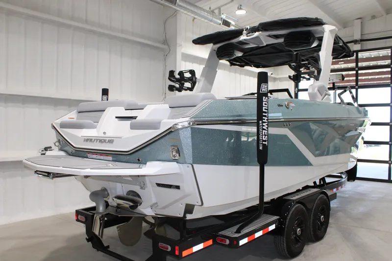 Slide: The Image of 2026 Nautique Super Air Nautique G25 boat in showroom, featuring sleek design and modern features. - 2