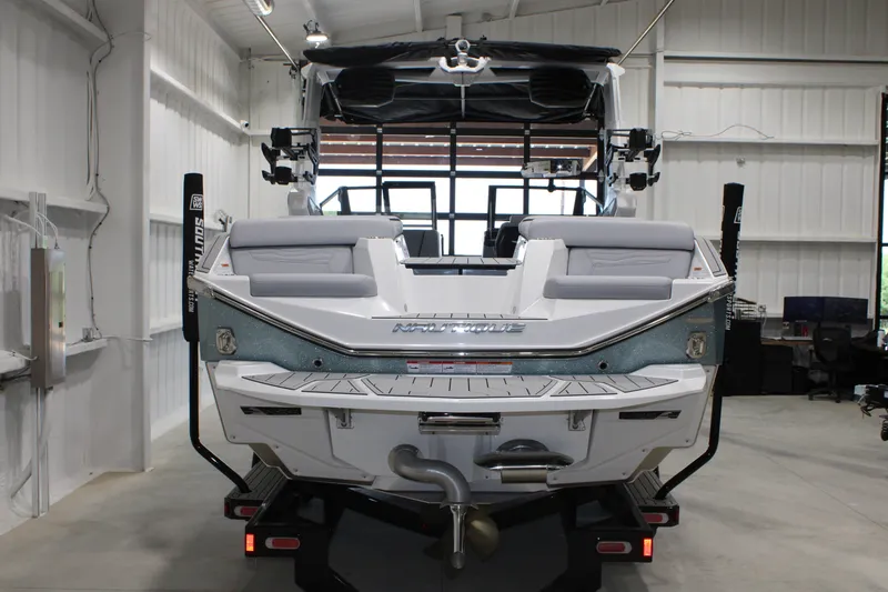 Slide: The Image of 2026 Nautique Super Air Nautique G25 boat in a showroom, rear view. - 3