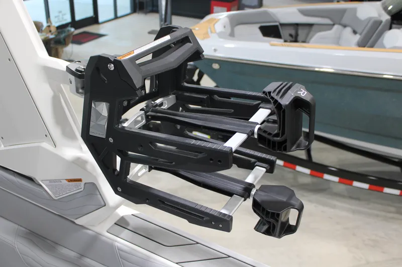 Slide: The Image of 2026 Nautique Super Air Nautique G25 wakeboard rack detail in showroom setting. - 11