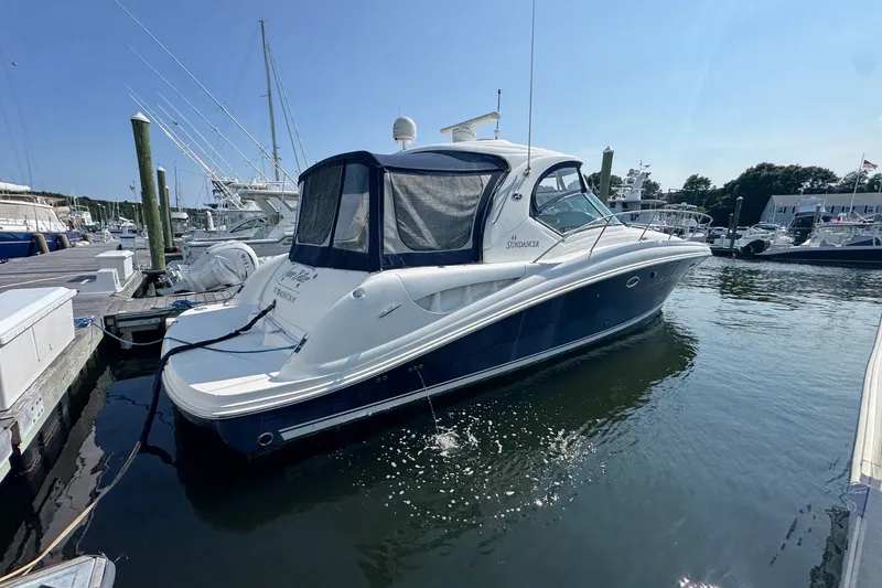 Slide: The Image of 2006 Sea Ray 44 Sundancer yacht docked at marina under clear blue sky. - 2