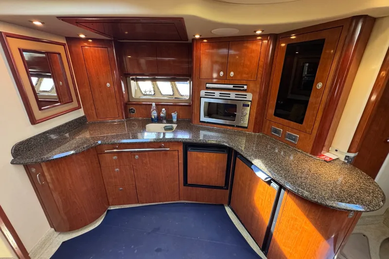 Slide: The Image of Luxurious 2006 Sea Ray 44 Sundancer yacht kitchen with sleek wood cabinetry and modern appliances. - 22