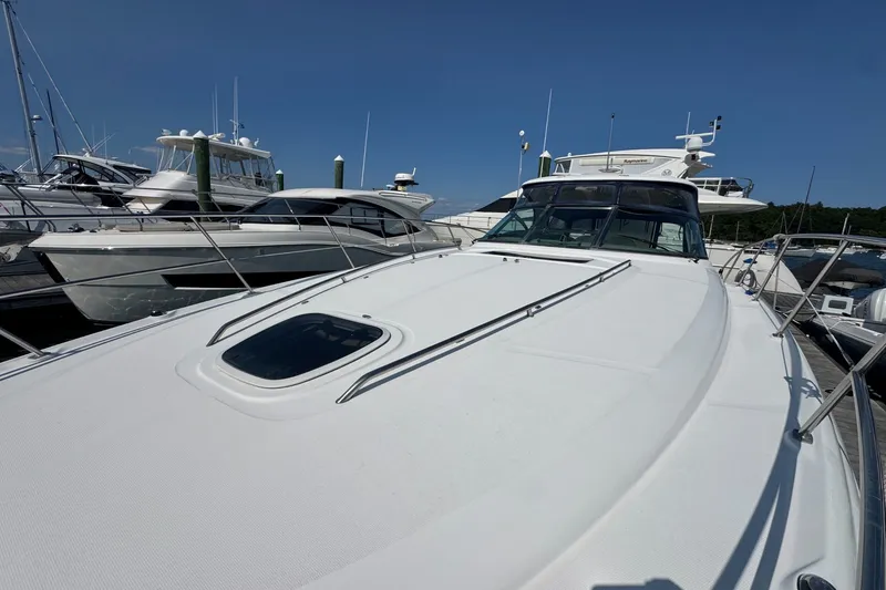 Slide: The Image of 2006 Sea Ray 44 Sundancer yacht docked at marina under clear blue sky. - 3