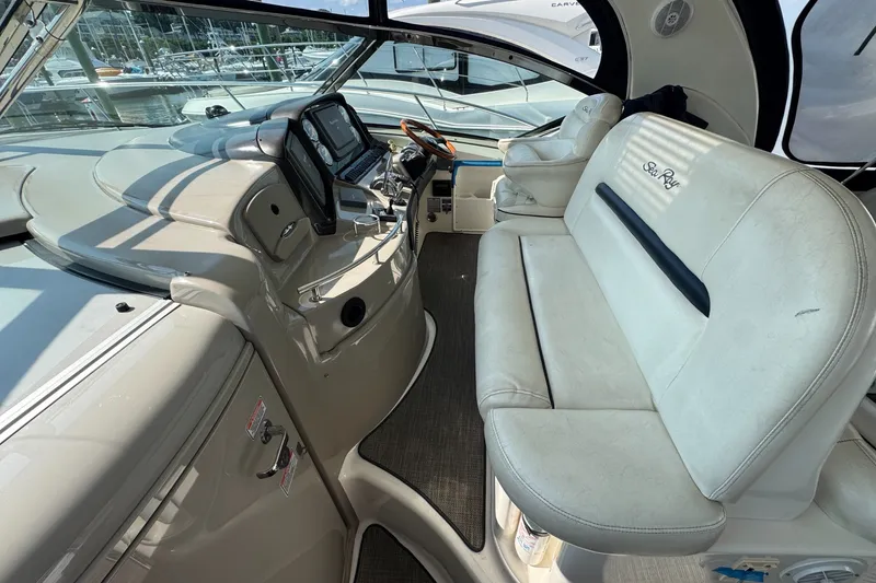 Slide: The Image of 2006 Sea Ray 44 Sundancer cockpit with plush seating and modern navigation controls. - 12