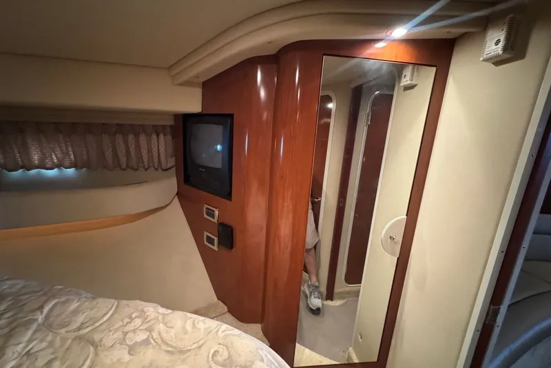Slide: The Image of 2003 Sea Ray 410 Sundancer cabin interior with TV, mirror, and cozy bed. - 41
