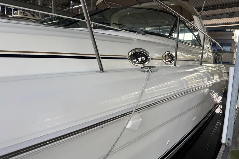 Slide: The Image of 2003 Sea Ray 410 Sundancer yacht in marina, showcasing sleek white exterior and chrome details. - 7