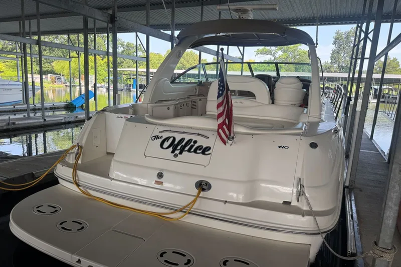 Slide: The Image of 2003 Sea Ray 410 Sundancer docked, featuring an American flag and "The Office" nameplate. - 16