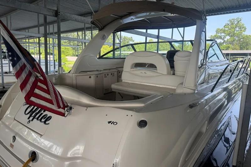 Slide: The Image of 2003 Sea Ray 410 Sundancer yacht docked, featuring sleek design and American flag. - 17
