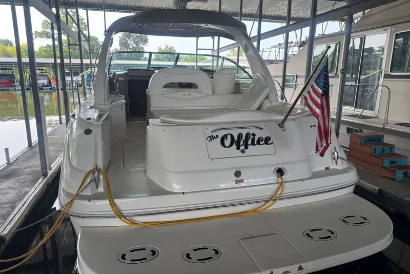 Slide: The Image of 2003 Sea Ray 410 Sundancer docked, featuring "The Office" name and American flag. - 14