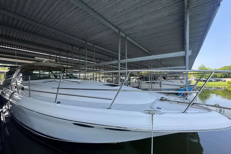Slide: The Image of 2003 Sea Ray 410 Sundancer yacht docked under a covered marina. - 10