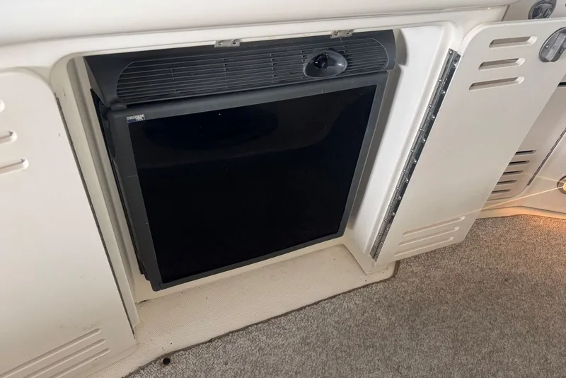Slide: The Image of Built-in mini fridge on 2003 Sea Ray 410 Sundancer yacht, with white cabinetry. - 22