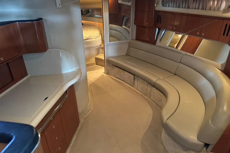 Slide: The Image of Luxurious interior of 2003 Sea Ray 410 Sundancer yacht with curved seating and cozy cabin. - 35