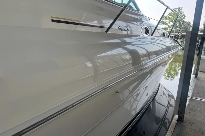 Slide: The Image of 2003 Sea Ray 410 Sundancer yacht docked, showcasing sleek exterior design and reflective surface. - 12