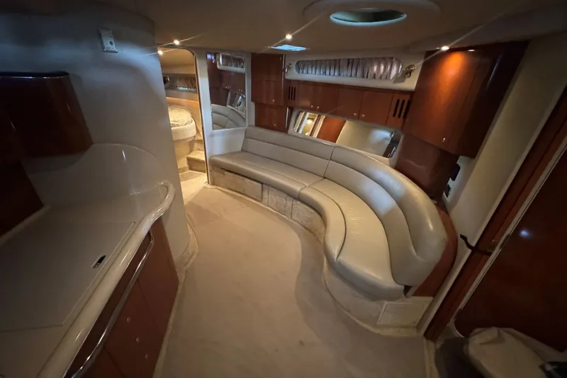 Slide: The Image of Luxurious interior of a 2003 Sea Ray 410 Sundancer yacht with curved seating and wood cabinetry. - 36