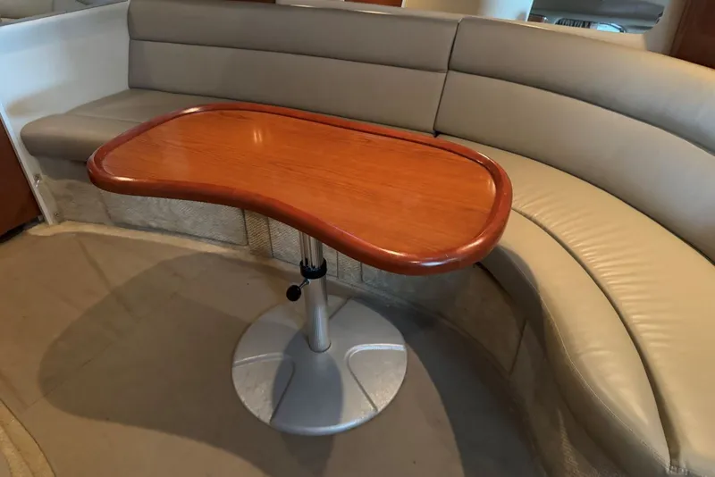 Slide: The Image of Interior of 2003 Sea Ray 410 Sundancer with curved seating and wooden table. - 47