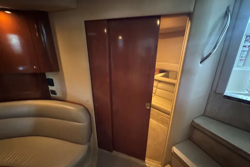 Slide: The Image of Interior of 2003 Sea Ray 410 Sundancer yacht with wooden door and leather seating. - 54