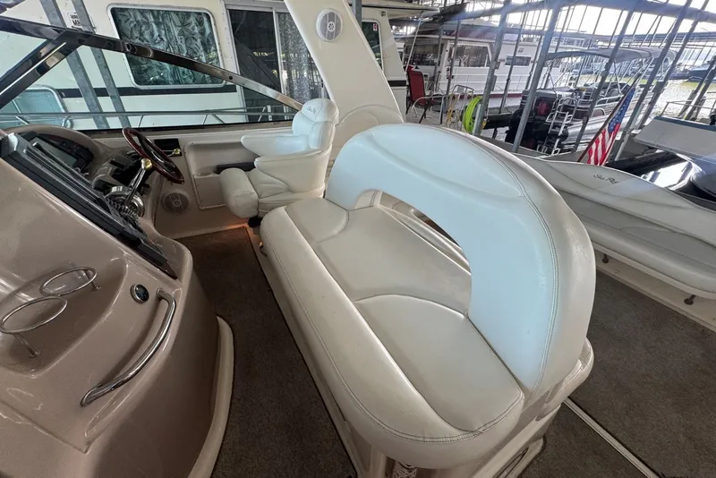 Slide: The Image of 2003 Sea Ray 410 Sundancer cockpit with white leather seating and helm controls. - 24