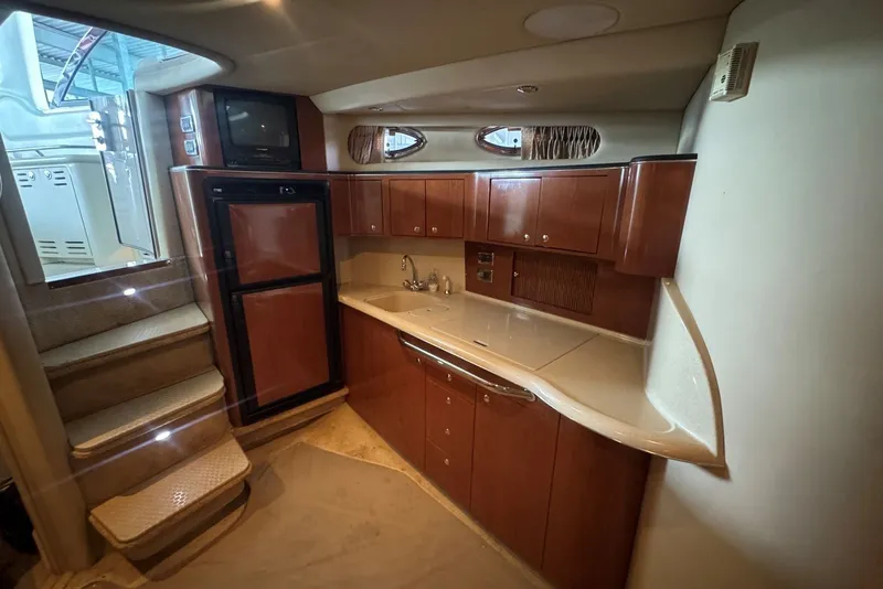Slide: The Image of Luxurious interior of 2003 Sea Ray 410 Sundancer yacht with kitchenette and stairs. - 37