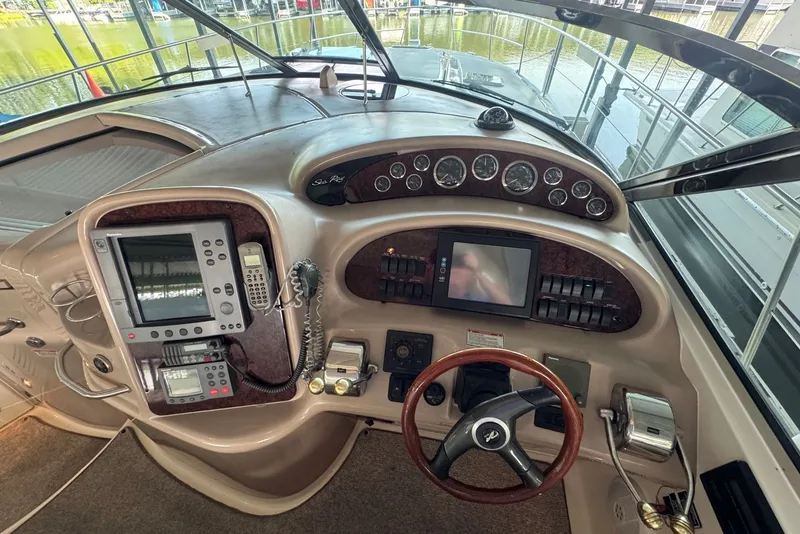 Slide: The Image of 2003 Sea Ray 410 Sundancer helm with navigation controls and steering wheel. - 27
