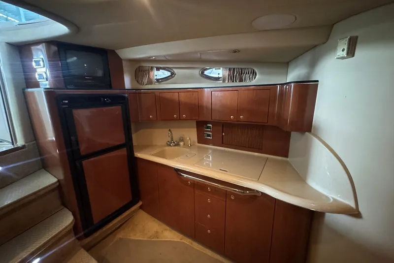 Slide: The Image of Luxurious 2003 Sea Ray 410 Sundancer yacht interior kitchen with wood cabinetry and modern appliances. - 38
