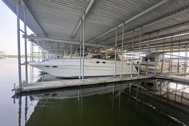 Slide: The Image of 2003 Sea Ray 410 Sundancer docked in a covered marina slip. - 1