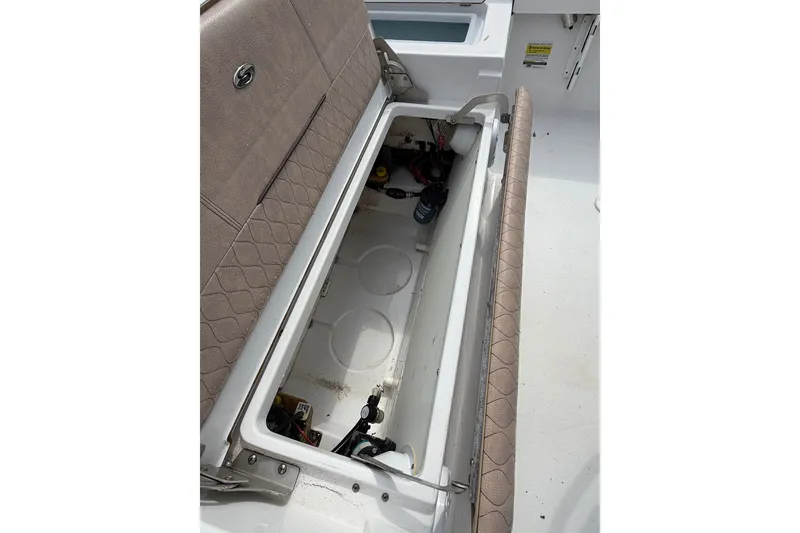 Slide: The Image of 2019 Sportsman Masters 227 Bay Boat storage compartment with open hatch and visible interior. - 9