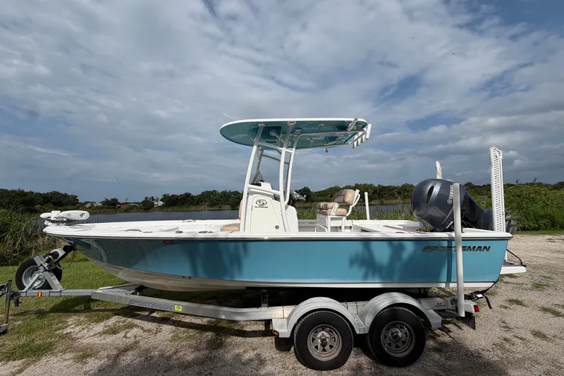 The Image of 2019 Sportsman Masters 227 Bay Boat on trailer, parked outdoors under cloudy sky. - 0