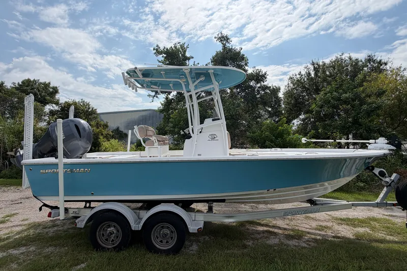 Slide: The Image of 2019 Sportsman Masters 227 Bay Boat on trailer, blue hull, parked outdoors. - 2