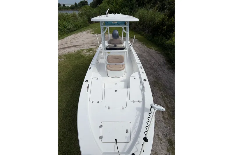 Slide: The Image of 2019 Sportsman Masters 227 Bay Boat on grassy path, showcasing spacious deck and seating. - 5