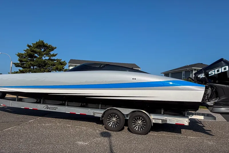 The Image of 2026 Doug Wright 36 powerboat on trailer, featuring sleek design and blue accents. - 0