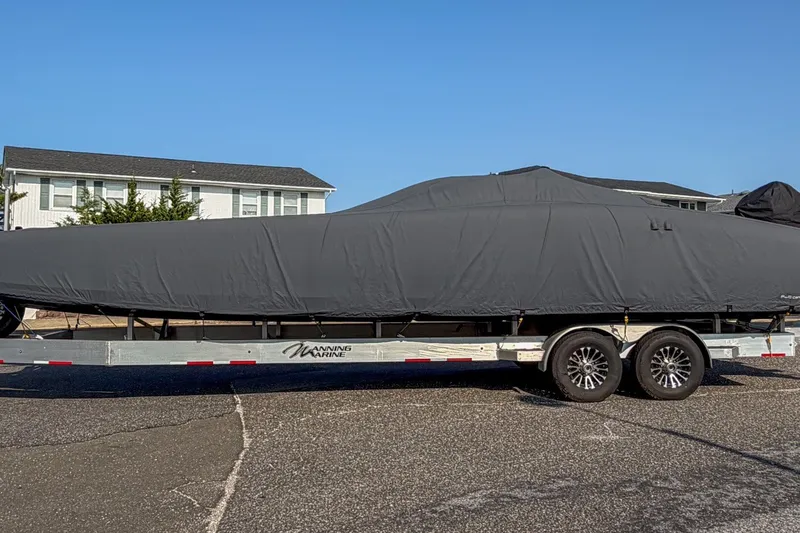 Slide: The Image of Covered Doug Wright 36 boat on trailer, 2026 model, parked outdoors. - 2