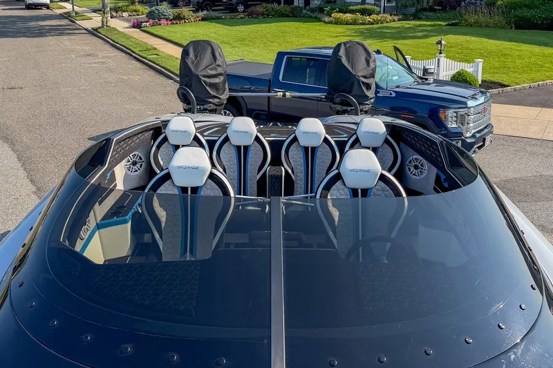 Slide: The Image of 2026 Doug Wright 36 boat with sleek seating and modern design, parked on a residential street. - 4